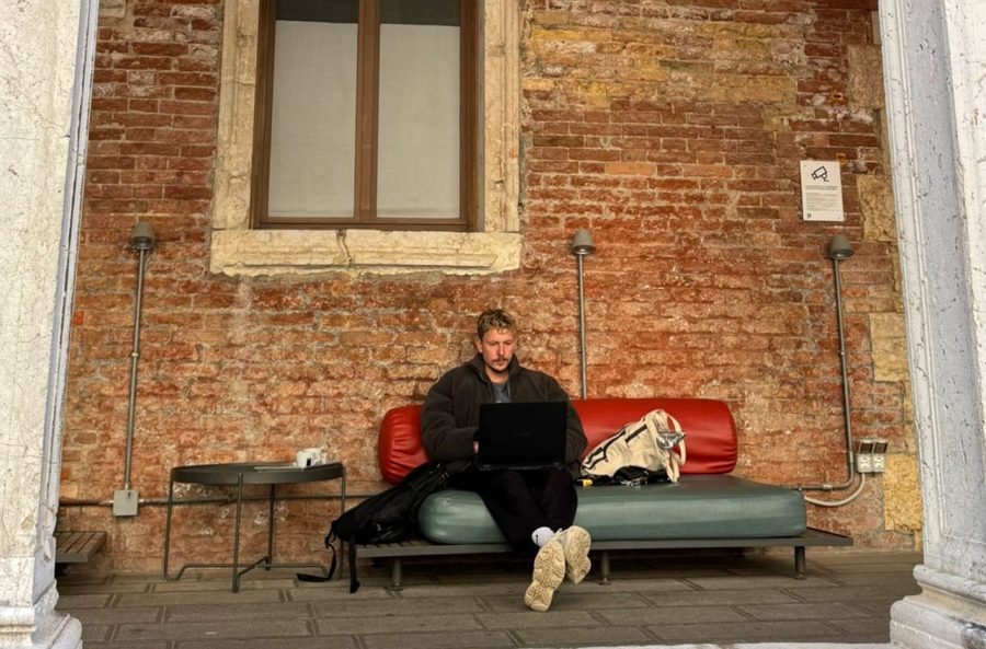 André Disselkamp arbeitet am Laptop unter einem Torbogen